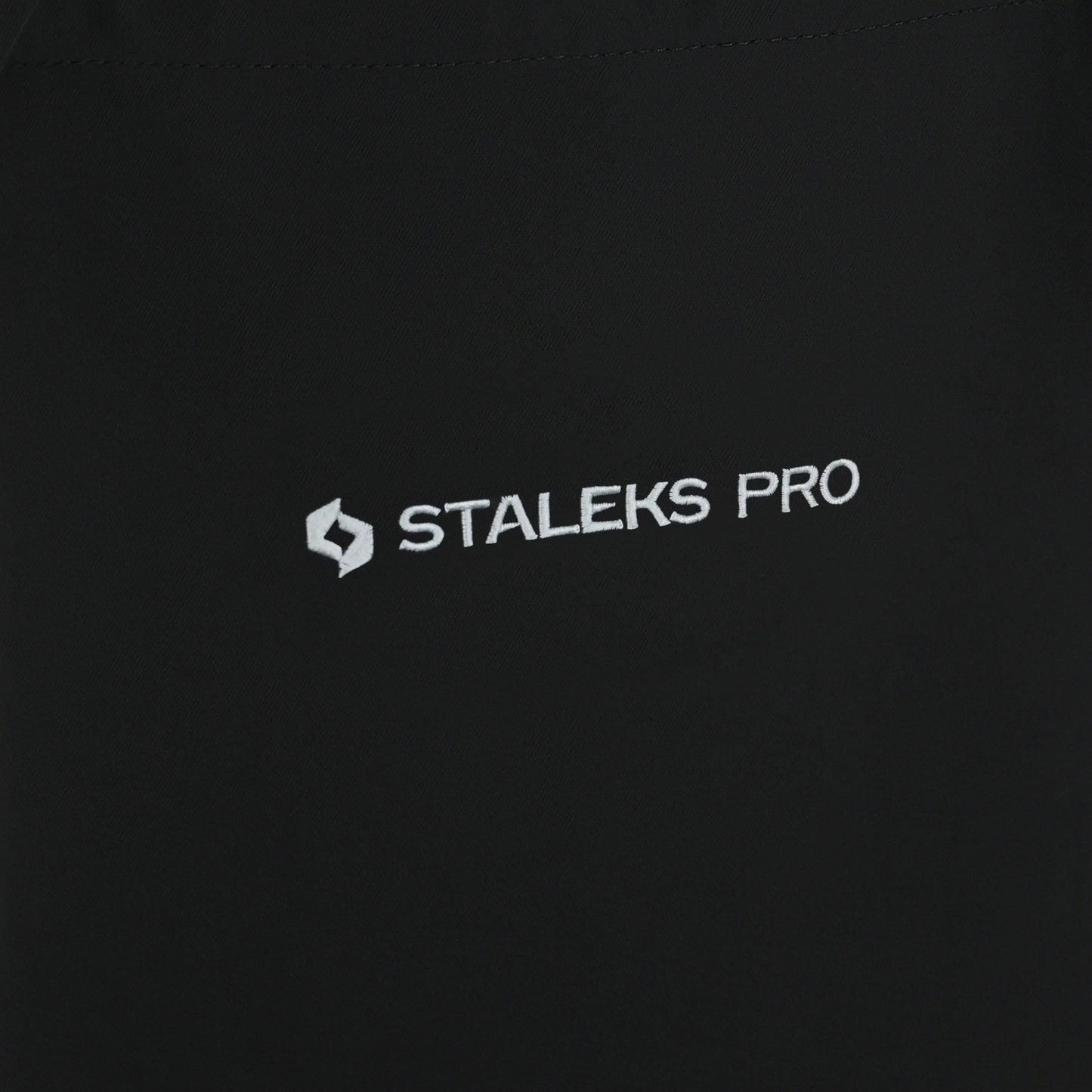 Logo STALEKS PRO brodé sur tablier noir, détail.