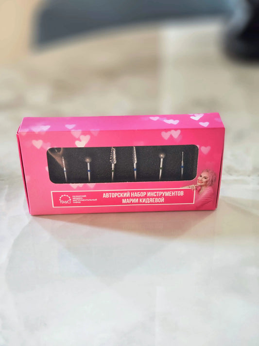 Kit de 6 embouts pour ponceuse à ongles présenté dans une boîte rose avec mousse de protection, idéal pour la manucure professionnelle.