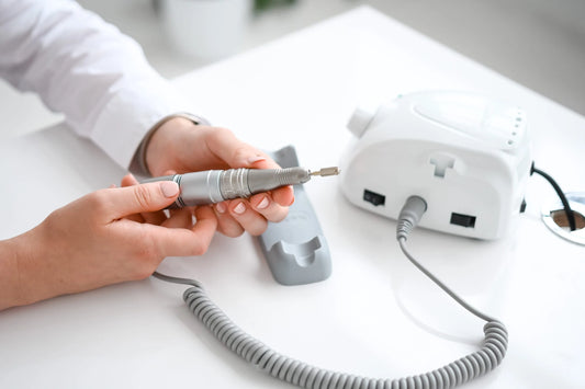 Prothésiste ongulaire tenant la pièce à main de la ponceuse Saeyang Marathon 3 Champion lors d’une utilisation professionnelle.