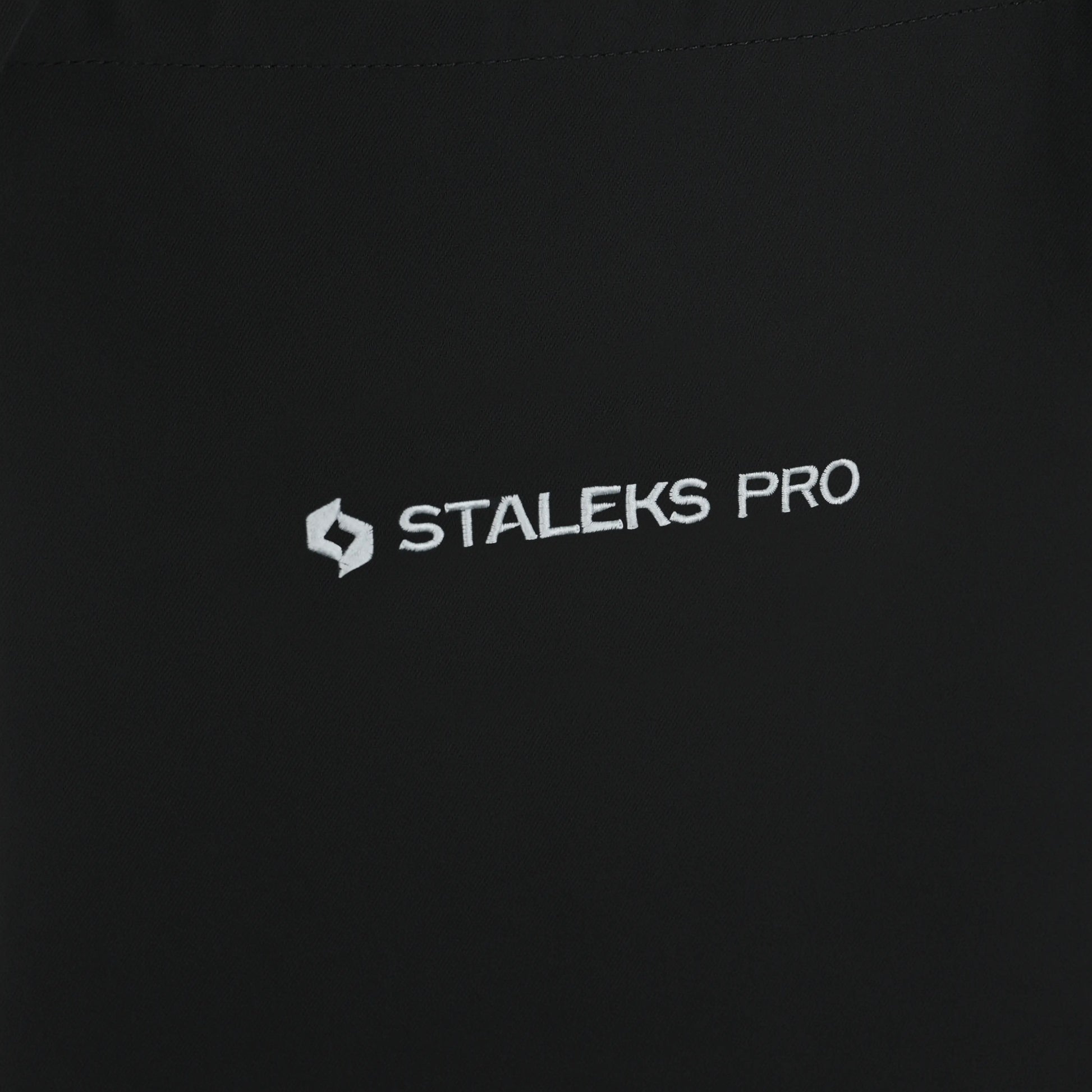 Logo STALEKS PRO brodé sur tablier noir, détail.