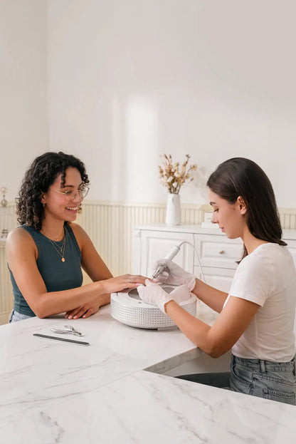 Prothésiste ongulaire utilisant le collecteur ONAIL Tornado No.1 pendant une manucure avec sa cliente.